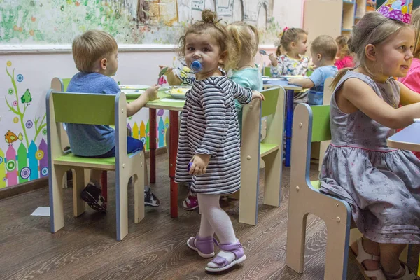 2019.01.22, Moskova, Rusya. Kameraya bakan küçük küçük kız. Anaokulunda yemek yeen çocuklar.