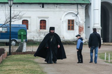 2010.04.17, Istra, Rusya. siyah anr turist manastır topraklarında yürüyüş şişman rahip. 