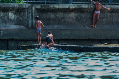 2011.04.30, Bangkok, Tayland. Koyda oynayan küçük çocukların nehir manzarası. Suya atlayan çocuklar. 