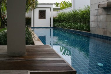 2011.05.05, Phuket, Tayland. Villa bahçesinde palmiye ağaçlarıyla çevrili yüzme havuzu.