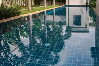 2011.05.05, Phuket, Tayland. Villa bahçesinde palmiye ağaçlarıyla çevrili yüzme havuzu.