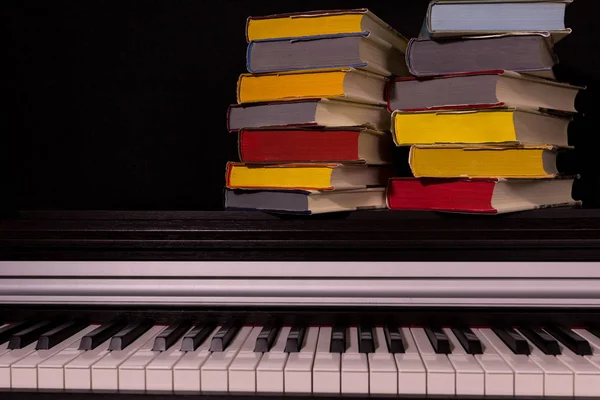 黒い背景にピアノの色の本のスタック 教育と読書の概念 — ストック写真