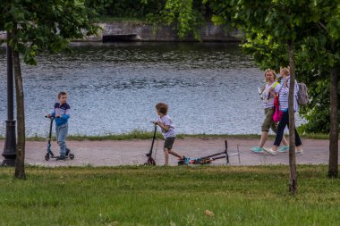 2019.06.01, Moskova, Rusya. Nehir kıyısında scooter kullanan bir çocuk. Bir çocuğun aktif yaşam tarzı.