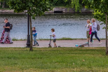 2019.06.01, Moskova, Rusya. Nehir kıyısında scooter kullanan bir çocuk. Bir çocuğun aktif yaşam tarzı.