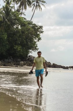 2011.05.07, Phuket, Tayland. Asya'yı dolaşın. Phuket plajı boyunca yürüyen bir Rus adam, ön yan görünüm.