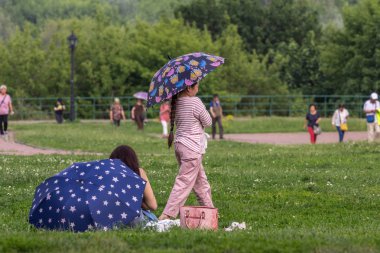 2019.05.31, Moskova, Rusya. Parkta şemsiyeyle yürüyen Asyalı bir kız. Moskova'nın tarihi yerinde Turistler.