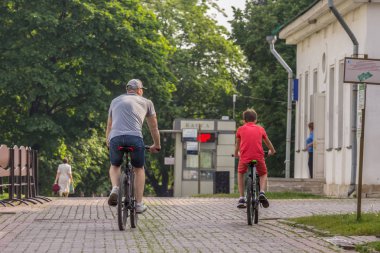 2019.05.31, Moskova, Rusya. Baba ve oğlu parkta bisiklete biniyor, arka taraf manzarası. Yaz aylarında aile harcamaları aktif meslekler.