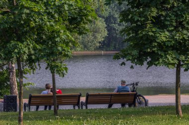 2019.05.31, Moskova, Rusya. Nehir kıyısındaki bankta oturan bir grup insan. İşten sonra yürümek