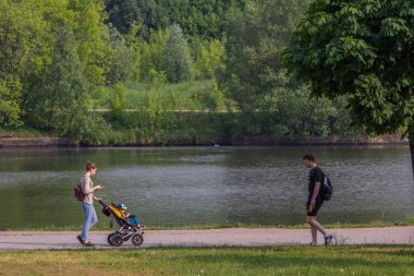 2019.05.31, Moskova, Rusya. Yaz günlerinde nehir kıyısında dolaşan bir grup insan. İşten sonra yürümek.