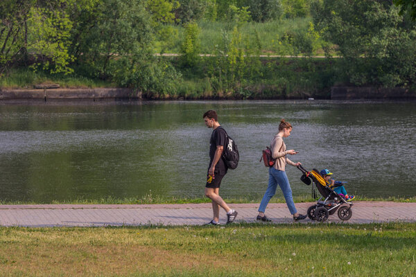 2019.05.31, Moscow, Russia. Group of people walking around river bank in summer day. Walking after work.
