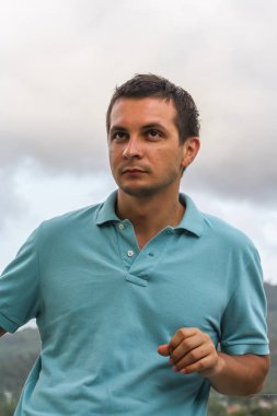 2011.05.10, Phuket, Tayland. Otelin çatısında cam çitlerin yanında duran genç bir adam. Phuket plajının arka planında kameraya bakan bir adam.