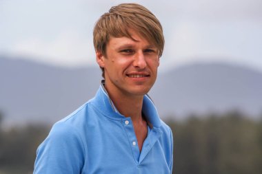 2011.05.10, Phuket, Tayland. Otelin çatısındaki kanepede oturan genç bir adam. Kameraya bakan bir adam. Phuket Turizm.