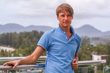 2011.05.10, Phuket, Tayland. Otelin çatısındaki kanepede oturan genç bir adam. Kameraya bakan bir adam. Phuket Turizm.