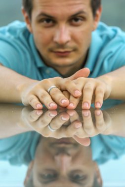 2011.05.10, Phuket, Tayland. Phuket doğanın backgrounf üzerinde cam masa nın yanında oturan genç bir adamın portresi.