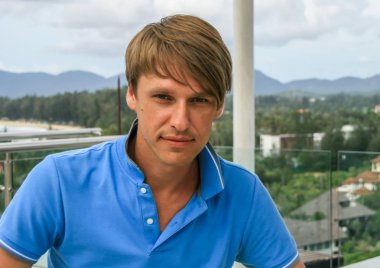 2011.05.10, Phuket, Tayland. Otelin çatısındaki kanepede oturan genç bir adam. Kameraya bakan bir adam. Phuket Turizm.