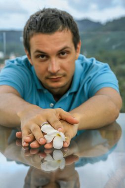 2011.05.10, Phuket, Tayland. Phuket doğanın backgrounf üzerinde cam masa nın yanında oturan genç bir adamın portresi.