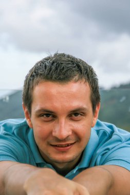 2011.05.10, Phuket, Tayland. Phuket doğanın backgrounf üzerinde cam masa nın yanında oturan genç bir adamın portresi.