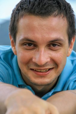 2011.05.10, Phuket, Tayland. Phuket doğanın backgrounf üzerinde cam masa nın yanında oturan genç bir adamın portresi.