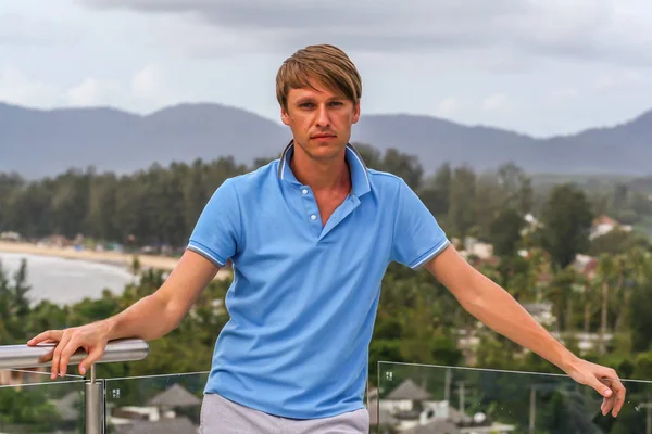 2011.05.10, Phuket, Tayland. Otelin çatısındaki kanepede oturan genç bir adam. Kameraya bakan bir adam. Phuket Turizm.