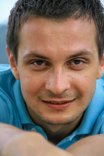 2011.05.10, Phuket, Tayland. Phuket doğanın backgrounf üzerinde cam masa nın yanında oturan genç bir adamın portresi.