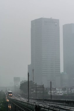2011.05.14, Bangkok, Tayland, ulaşım sistemi. Yağmur gününde gökdelenlerin arka planda metro treni. Güçlü yağmur hava, bulanıklık ve tahıl etkisi. 