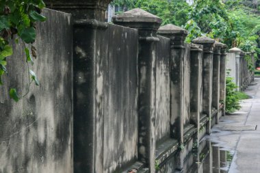 2011.05.15, Bangkok, Tayland. Cadde boyunca çitin eski bir taş duvarı. Bangkok çevresinde yürüyüş.