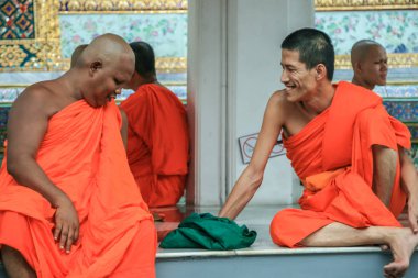 2011.05.16, Bangkok, Tayland. Bir grup Budist keşiş, turist olarak Büyük Saray 'ın gölgesinde dinleniyorlar..