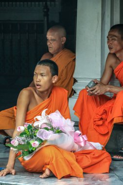 2011.05.16, Bangkok, Tayland. Bir grup Budist keşiş, turist olarak Büyük Saray 'ın gölgesinde dinleniyorlar..