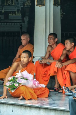 2011.05.16, Bangkok, Tayland. Bir grup Budist keşiş, turist olarak Büyük Saray 'ın gölgesinde dinleniyorlar..