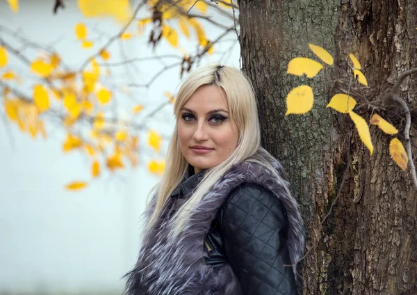 2017 モスクワ ロシア 木のそばに立つ毛皮の黒いジャケットを着た若い魅力的な女性 秋の公園を散策 — ストック写真