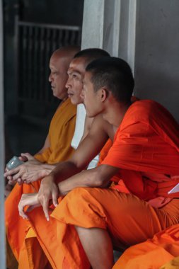 2011.05.16, Bangkok, Tayland. Bir grup Budist keşiş, turist olarak Büyük Saray 'ın gölgesinde dinleniyorlar..