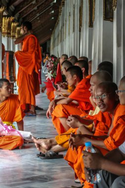 2011.05.16, Bangkok, Tayland. Bir grup Budist keşiş, turist olarak Büyük Saray 'ın gölgesinde dinleniyorlar..