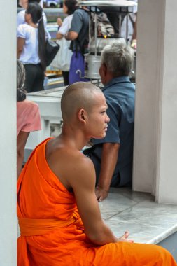 2011.05.16, Bangkok, Tayland. Bir grup Budist keşiş, turist olarak Büyük Saray 'ın gölgesinde dinleniyorlar..