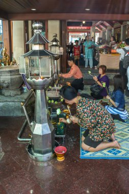 2011.05.16, Bangkok, Tayland. Asyalı kadın tapınakta mum yakıyor. Tapınakta dini tören..