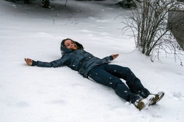 2011.01.02, Maloyaroslavets, Rusya. Genç ve güzel bir kadın karda yatıyor, bulanık ve tahıl etkisi altında. Komik kış eğlencesi.