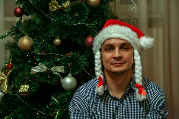 2011 Maloyaroslavets Russia 一个戴着白雪公主帽的年轻人坐在圣诞树的背景上 满脸模糊 五彩斑斓 — 图库照片