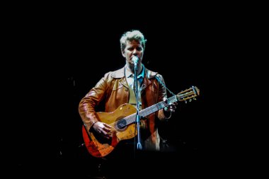 19.10.2012, Moskova, Rusya. Brazzaville 'li Soloist - Amerikalı bağımsız pop grubu - sahnede mikrofon başında gitar çalıyor..