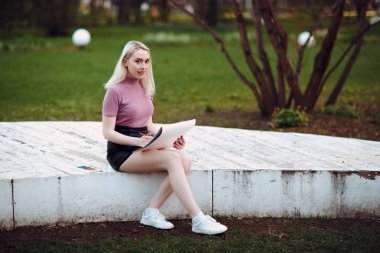 Park içinde genç güzel kız ressam çizmek