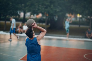 Adam basketbol oynuyor ve halka içine topu atar