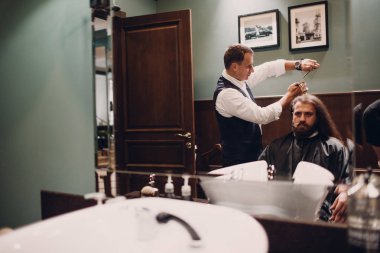 Ahşap iç berber dükkanı. Sakallı modeli adam ve Kuaför.