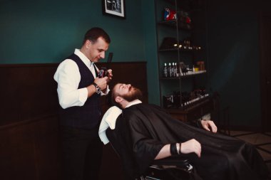 Ahşap iç berber dükkanı. Sakallı modeli adam ve Kuaför.