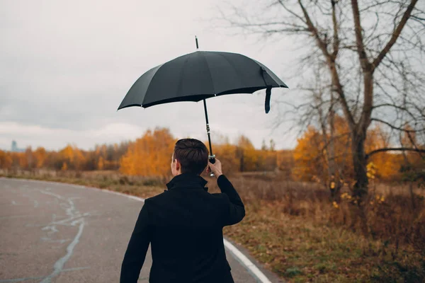 Молодой Человек Черном Пальто Идет Дождем Зонтиком — стоковое фото