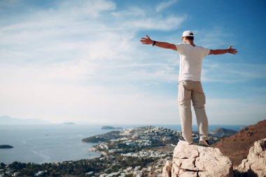 Genç erkek dağcı uçurumun tepesinde