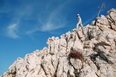 Genç erkek dağcı uçurumun tepesinde