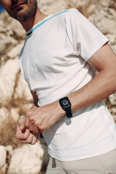 Young male rock climber with electronic smart watch