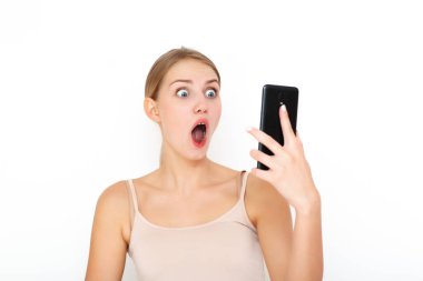 Aşırı mutlu, heyecanlı bir kadın maaş hakkında bilgi veren, iyi haberler veren, cep telefonuna bakan, mutluluktan hareketler yapan, tek başına ayakta duran bir mesaj almaktan memnun. Tepki konsepti
