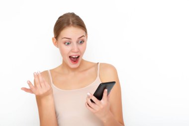Aşırı mutlu, heyecanlı bir kadın maaş hakkında bilgi veren, iyi haberler veren, cep telefonuna bakan, mutluluktan hareketler yapan, tek başına ayakta duran bir mesaj almaktan memnun. Tepki konsepti