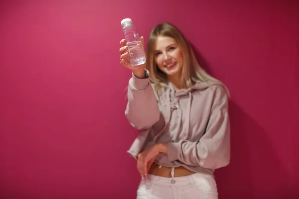 Молодая Женщина Бутылкой Питьевой Воды Розовом Фоне — стоковое фото