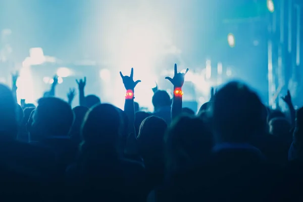 音乐会 活动或派对概念 在现场附近举起手来的人 聚光灯下 彩色蓝光 — 图库照片