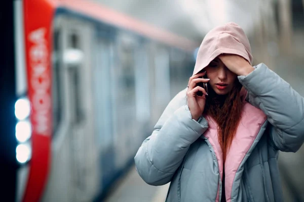 在地铁引擎盖中 带手机的正红发年轻女性 — 图库照片